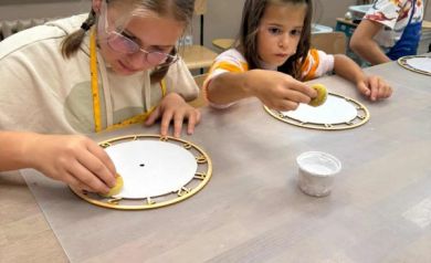 Dzieci podczas warsztatów z tworzenia zegarów. 