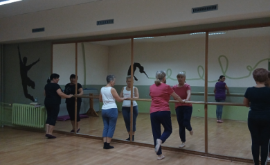 Uczestniczki zajęć przy drążkach. Wykonują ćwiczenia.