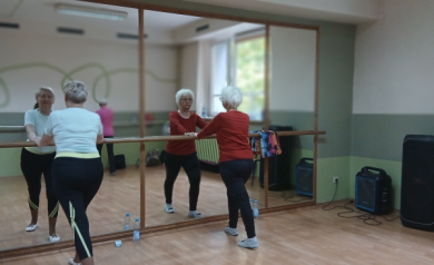 Dwie uczestniczki zajęć przy drążkach wykonują ćwiczeń.