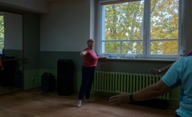 Kobieta prezentująca pozostałym uczestnikom kroki taneczne.