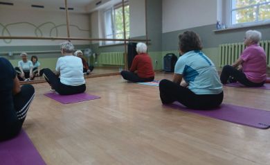 Ćwiczenia wykonywane przez uczestniczki zajęć. Siedzą na matach.