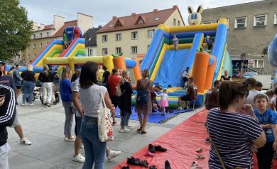 Atrakcje dla dzieci. Dmuchane zjeżdżalnie. Dzieci bawią się pod czujnym okiem rodziców.