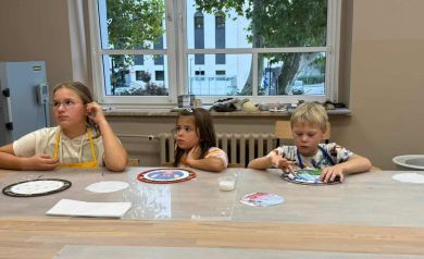 Dwie dziewczynki i chłopiec pracujący nad swoimi zegarami. 