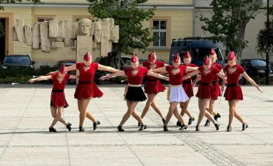 Na zdjęciu występ ubranych w czerwone stroje mażoretek.