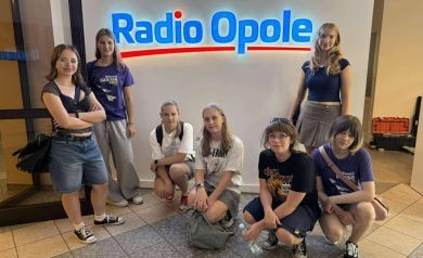 Na zdjęciu siedem dziewcząt przy szyldzie Radia Opole.  - powiększ