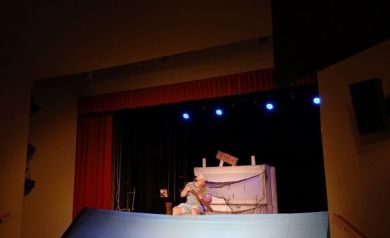 Scena, na której są dekoracje i występujący aktor. 