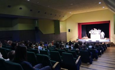 Na pierwszym planie publiczność, zaś na drugim aktorzy podczas odgrywania sceny. 