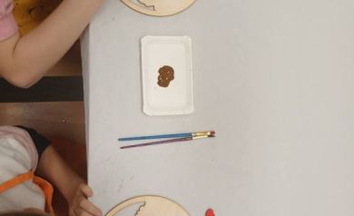 Zdjęcie przedstawia malowanie przez dwie dziewczynki farbami swoich prac. 