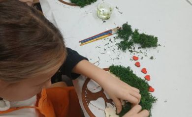 Na zdjęciu dwie dziewczynki pracujące nad swoimi dziełami. 