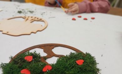 Zbliżenie na wykonane ,,Drzewko życia', w tle dziewczynka pracująca nad swoim dziełem. 