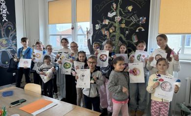 Grupa dzieci przedstawiająca swoje prace plastyczne