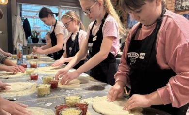 Grupa dzieci pracująca nad ciastem do pizzy