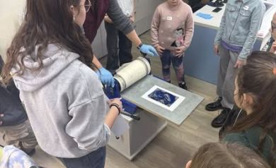 Dzieci są w pracowni plastycznej, patrzą na pracę artysty Adama Michalika