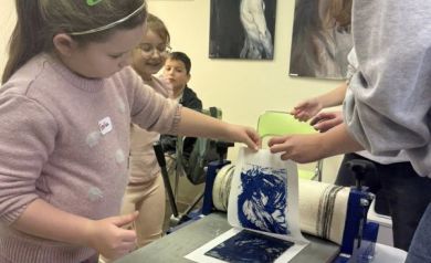 Dziewczynka odbija swoją pracę na papierze