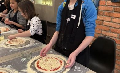 Chłopak pokazuje swoją pizzę