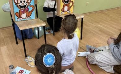 Grupa dzieci bawiąca się z niespodziankowymi pudełkami z małpkami