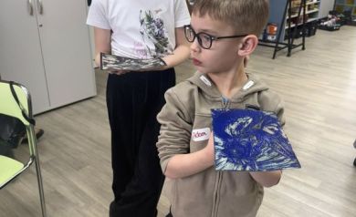 Chłopak i dziewczyna przedstawiają swoje prace linorytowe