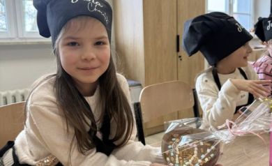 Dziewczynka pokazuje stworzony przez siebie wyrób czekoladowy