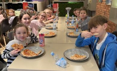 Dzieci jedzą pizzę