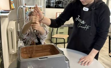 Dwie dziewczynki pracujące przy płynnej czekoladzie