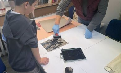 Pan pomaga chłopczykowi w tworzeniu linorytu