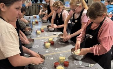 Grupa dzieci pracuje nad ciastem do pizzy