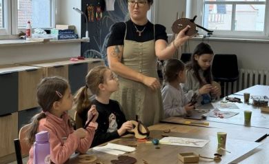 Pani pokazuje dzieciom maskę