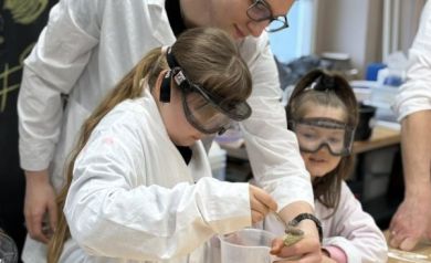 Mężczyzna pomaga dziewczynce w eksperymencie