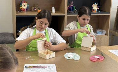 Dwie dziewczynki pracujące nad drewnianym pudełeczkiem