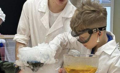 Mężczyzna pomaga chłopcowi wykonać eksperyment z dymem