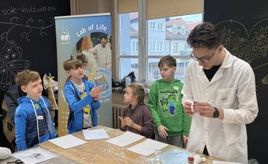 Grupa dzieci, jeden chłopak pyta o coś Pana