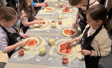 Dzieci smarujące pizzę sosem