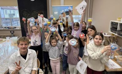 Dzieciaki pokazują prace z warsztatów laboratoryjnych