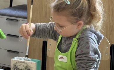 Dziewczyna maluje drewniane pudełeczko