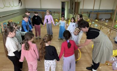 Grupa dzieci stojąca w kółku w maskach na oczy