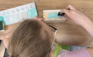 Dziewczynka malująca drewno