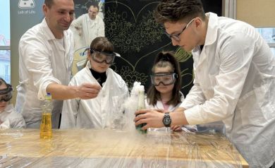 Dwaj Panowie pokazują dwóm dziewczynkom eksperyment z dymem