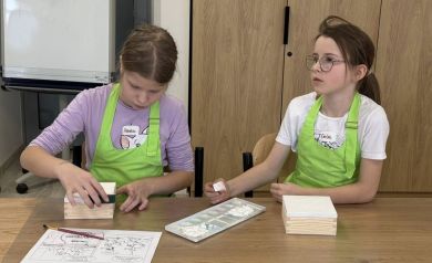 Dwie dziewczynki pracujące nad drewnianym pudełkiem