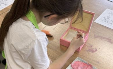 Dziewczynka maluje pudełko na różowo