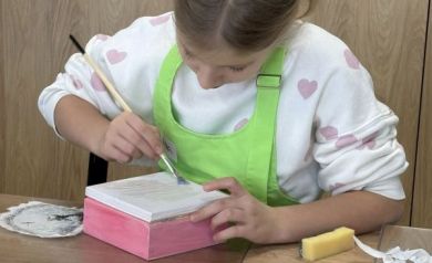 Dziewczynka maluje pudełko na różowo