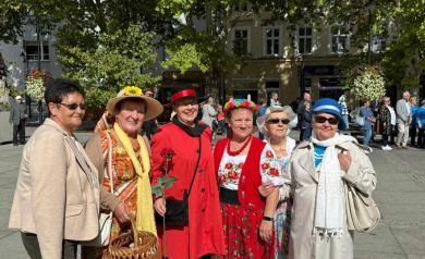 Na zdjęciu sześć kobiet ubranych w kolorowe stroje. Pozują do zdjęcia. W tle widać innych uczestników biorących udział w wydarzeniu.