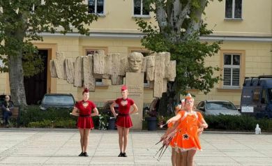 Na zdjęciu mażoretki w czerwonych i pomarańczowych strojach podczas swojego występu.