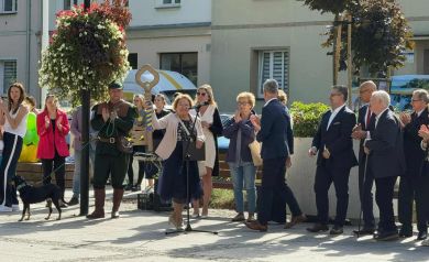 Na zdjęciu uczestnicy 5. Strzeleckiego Święta Seniorów. Jedna z kobiet unosi w ręce duży klucz do góry, w drugiej ręce trzyma czarną teczkę.
