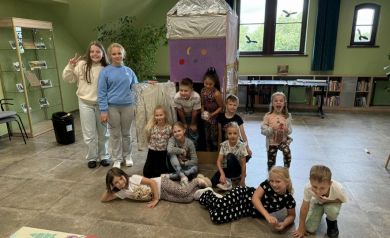 Dzieci ustawione do zdjęcia grupowego z wykonaną rakietą podczas zajęć kreatywnych w ramach Wakacji z SOK-iem. 