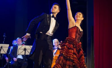 Para przedstawia choreografię taneczną na scenie.