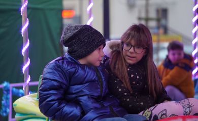 Chłopiec i dziewczynka rozmawiające z sobą będą na karuzeli. 