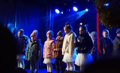 Występ dzieci na cenie. Scena oświetlona jest niebieskim światłem,. 