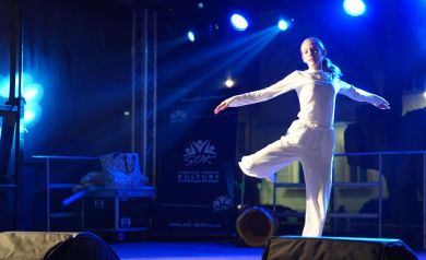 Występ na scenie tancerki ubranej na biało.