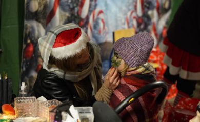 Kobieta malująca twarz dziecku. 