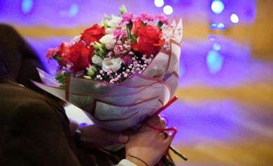 Na zdjęciu bukiet kolorowych kwiatów trzymany w dłoniach kobiety. 